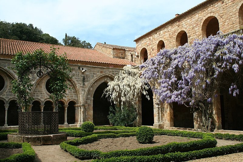 Cour de l'Abbaye de Fontfroide, avec des glycines violettes en fleurs